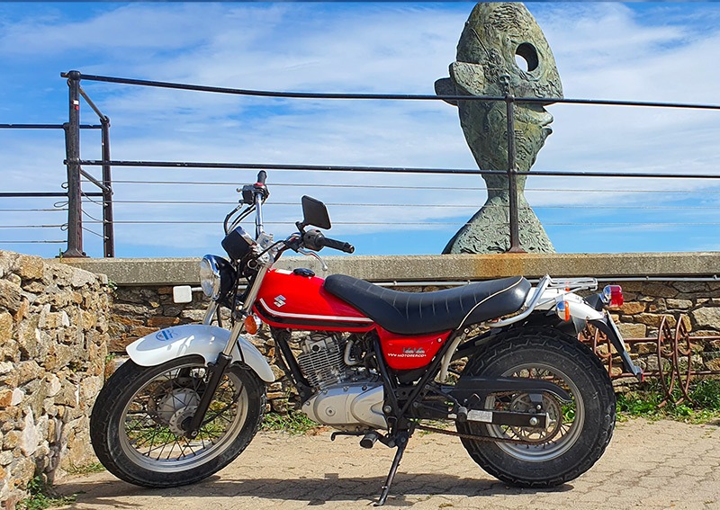 Moto Suzuki VanVan devant la statue du poisson — île d'Yeu